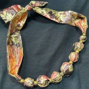 VTG 80s Bold Shiny Floral fabric knotted necklace with gold beads. Unique!!